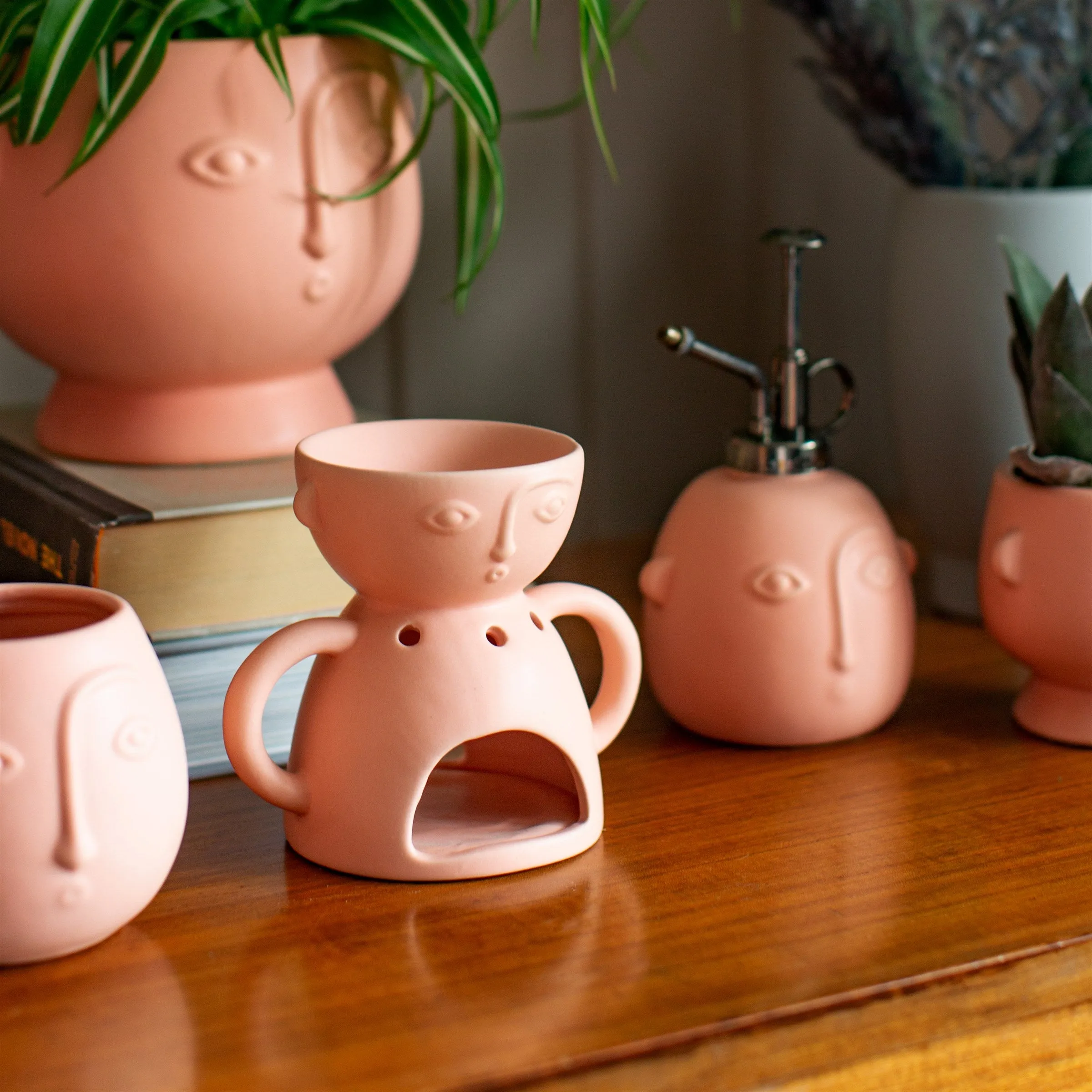 Abstract face styled oil burner in matte pink